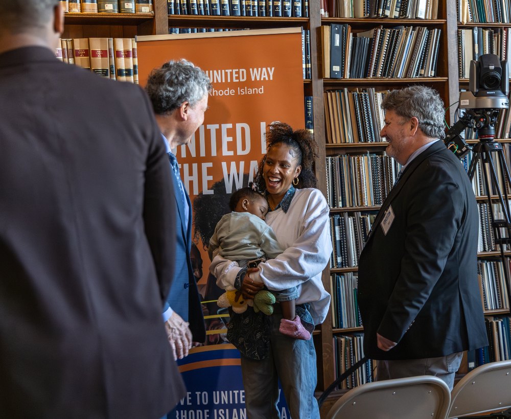 A parent holding a child at a community event