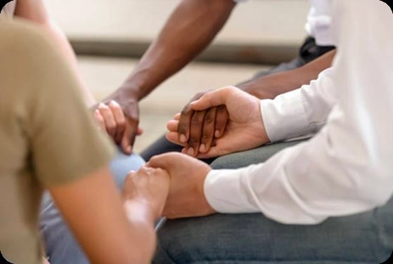 Two people holding hands in a supportive conversation