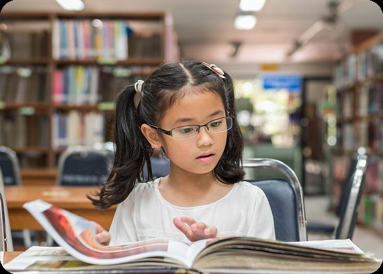 A young student reading in a library